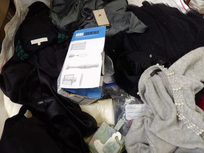a pile of clothes that is on a bed