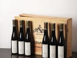six bouteilles de vin sont posées dans une caisse en bois sur une table