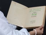 une personne tient un livre entre ses mains, sur fond noir