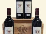 three bottles of red wine in a wooden crate on a white background
