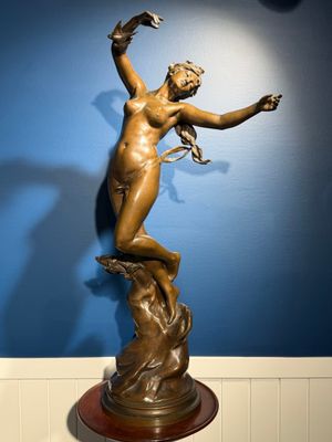 statue d'une femme sur un socle, dans une pièce aux murs bleus