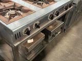 Dans une cuisine, plusieurs cuisinières en acier inoxydable sont empilées les unes sur les autres.