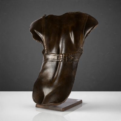 une photo d'une sculpture représentant une botte posée sur un socle en bois
