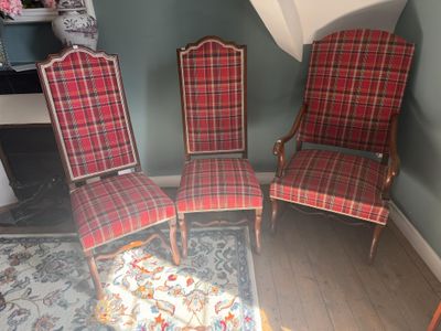 trois chaises à carreaux rouges placées dans une pièce, près d'une cheminée