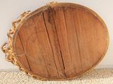 a large wooden bowl sitting on the floor next to a wall
