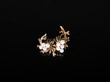 gros plan d'une paire de boucles d'oreilles sur une surface noire