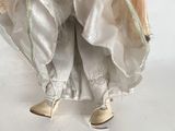 a doll that is dressed in a white dress and shoes