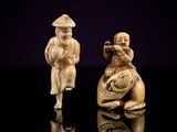 two carved figurines of a man and a woman playing a flute