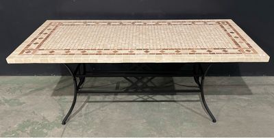 une table avec un plateau en mosaïque et des pieds en fer