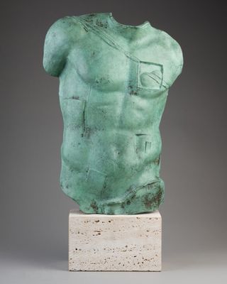 une statue représentant le torse d'un homme, posée sur un socle en marbre