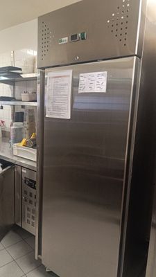 un réfrigérateur en acier inoxydable dans une cuisine équipée d'une poubelle