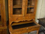 a wooden cabinet with a glass door on top of it