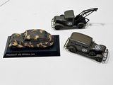 trois véhicules militaires miniatures exposés sur une surface blanche