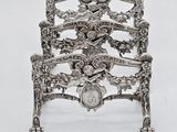 a silver chair that has a clock on the back of it