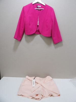une veste rose sur un cintre, à côté d'un short
