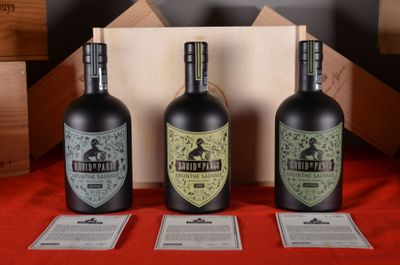 three bottles of wine are sitting on a table with a red cloth