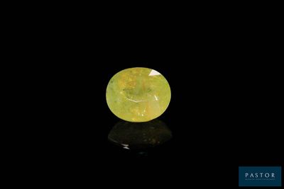 une pierre de jade jaune de forme ovale sur fond noir