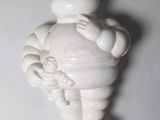 une petite figurine blanche représentant un homme tenant un bébé dans ses bras