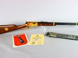 a rifle with a gun and other items on a table