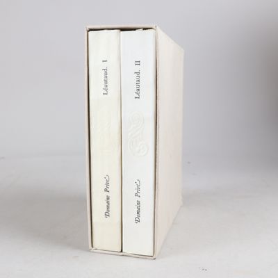 two books are stacked on top of each other on a white surface