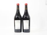 deux bouteilles de vin posées l'une à côté de l'autre sur une surface blanche