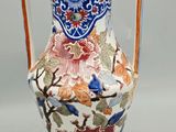 a vase with a handle that has flowers and birds on it