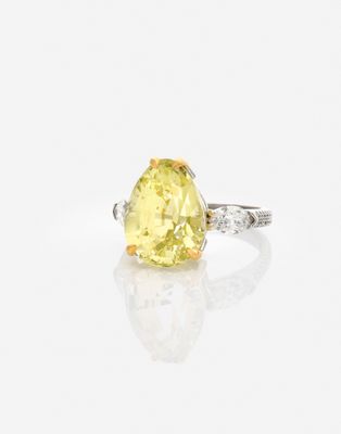 une bague sertie d'un diamant jaune et de diamants, posée sur un fond blanc
