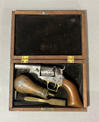 une petite boîte en bois contenant un pistolet