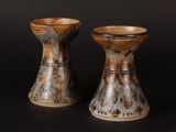 two vases sitting next to each other on a black surface