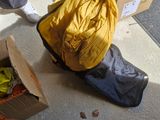a person standing next to a box of clothes and a bag of luggage