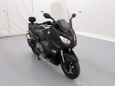 une moto noire garée dans une pièce aux murs blancs
