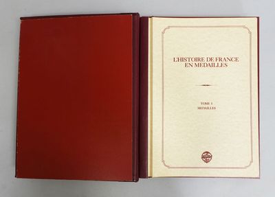 an open book with a red cover sitting on top of a white table