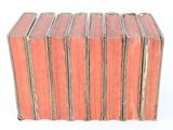 several old books stacked on top of each other on a white surface