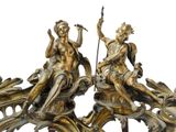 two statues of a man and a woman sitting on top of a clock