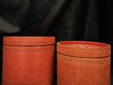 two red pots sitting next to each other on a black background