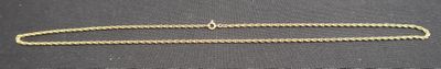 gold plated necklace with a long chain on a black surface