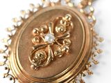 a close up of a gold necklace with a medallion on it