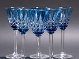 six blue wine glasses sitting on top of a table