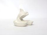 a white ceramic sculpture of a cat on a white surface
