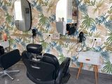 a picture of a hair salon with chairs and mirrors