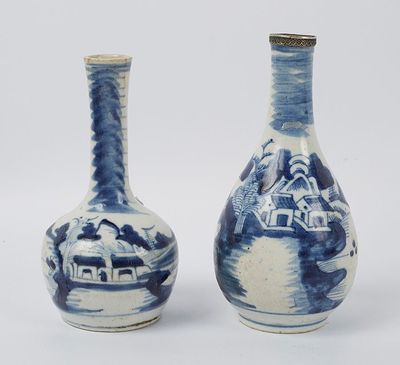 une paire de vases bleus et blancs ornés de maisons sur fond blanc
