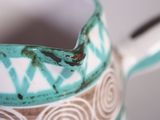 a blue and white pitcher with a pattern on it