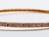 a close up of a gold bracelet with diamonds on it