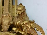 a gold clock with a lion on top of it