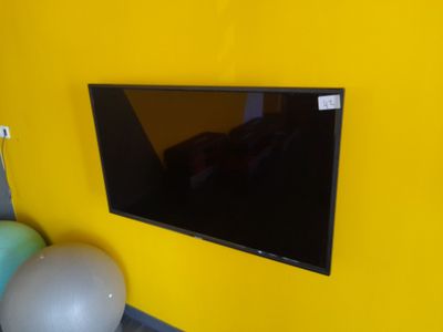 une télévision à écran plat accrochée à un mur jaune