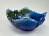 un bol bleu contenant une feuille verte