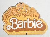 une photo d'une affiche Barbie accrochée à un mur