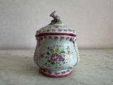 un vase blanc et rose orné d'un oiseau