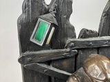 a bronze statue of a man with a cell phone in his hand