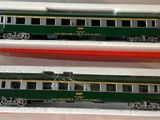 two green and white train cars sitting in a box